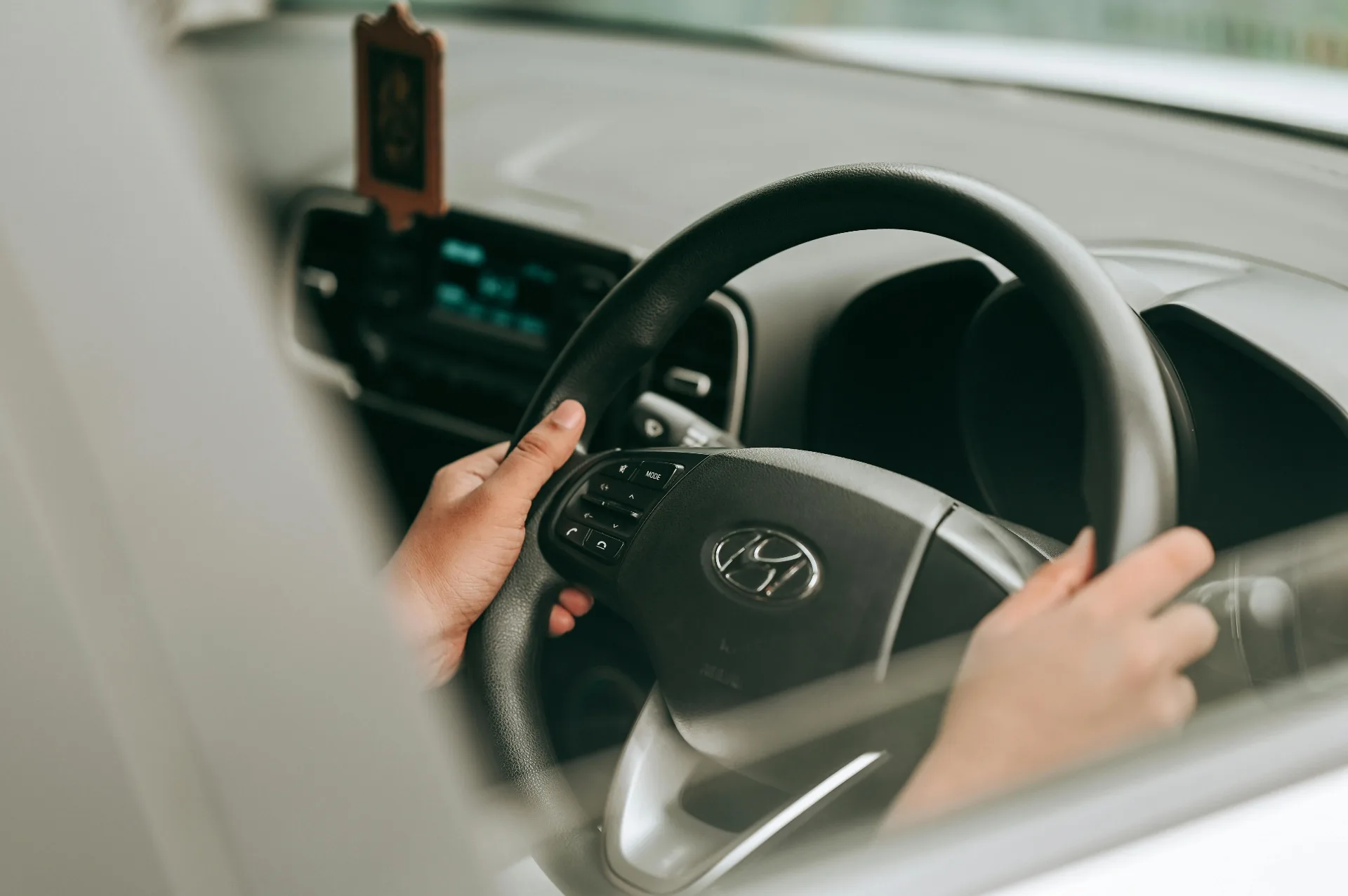 Person holding car keys in front of a silver SUV